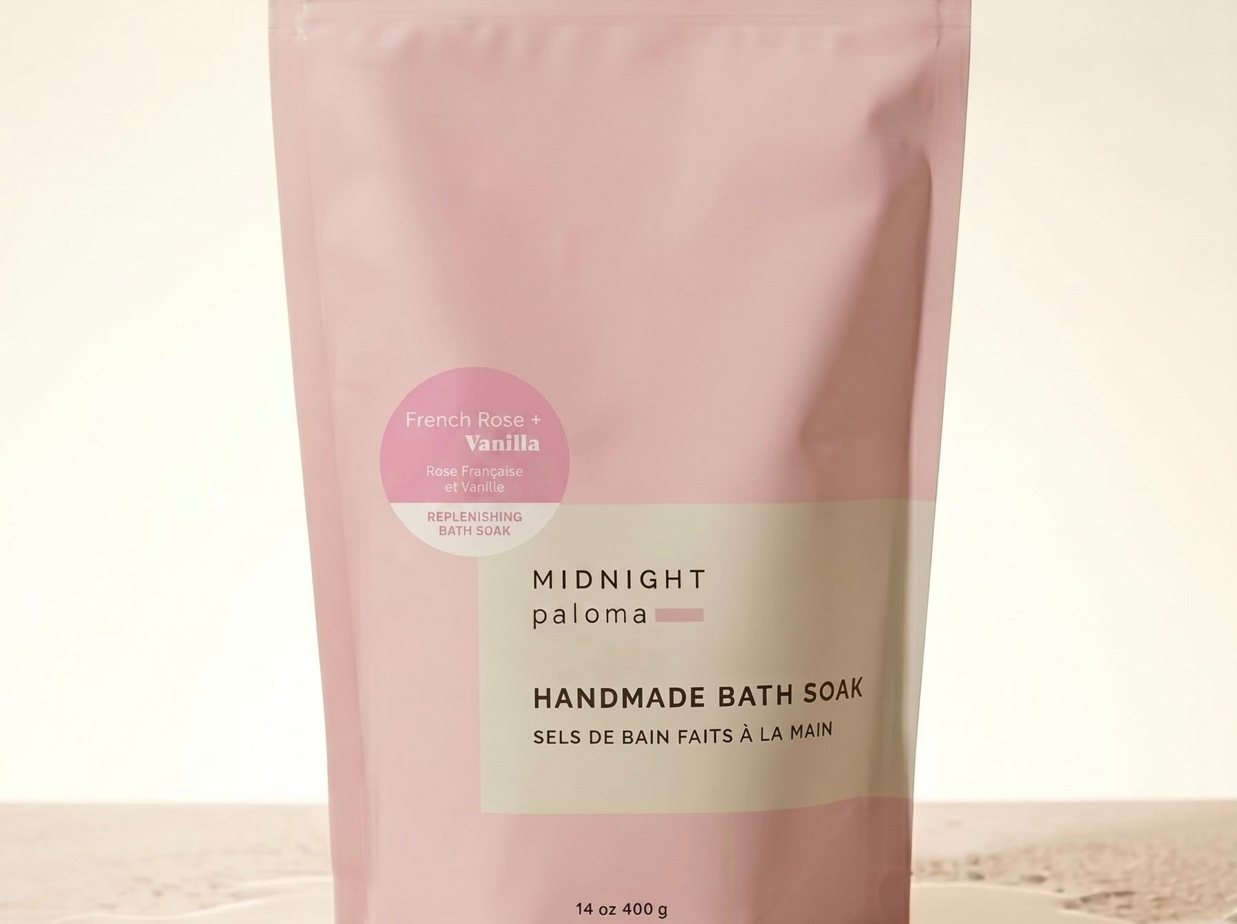 Pink packaging of handmade bath soak on a beige background