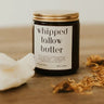 Jar of whipped tallow butter on a wooden surface with flowers.
