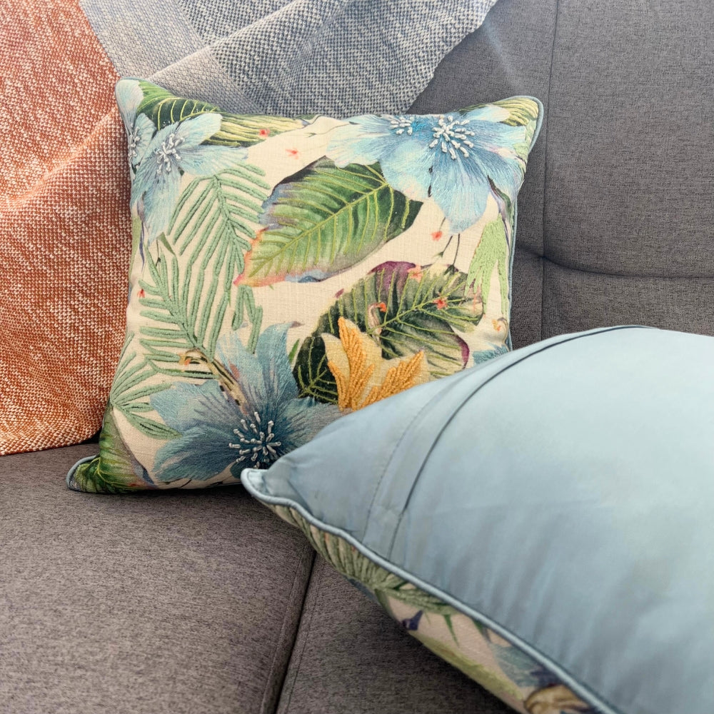 Floral-patterned pillow on a gray sofa with a textured backrest.