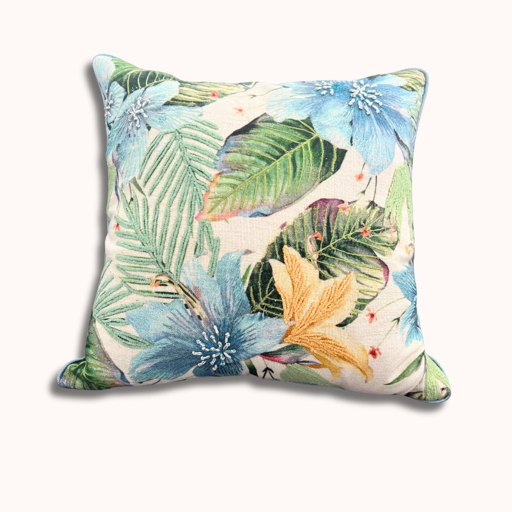 Decorative pillow with tropical leaf and flower pattern on a white background