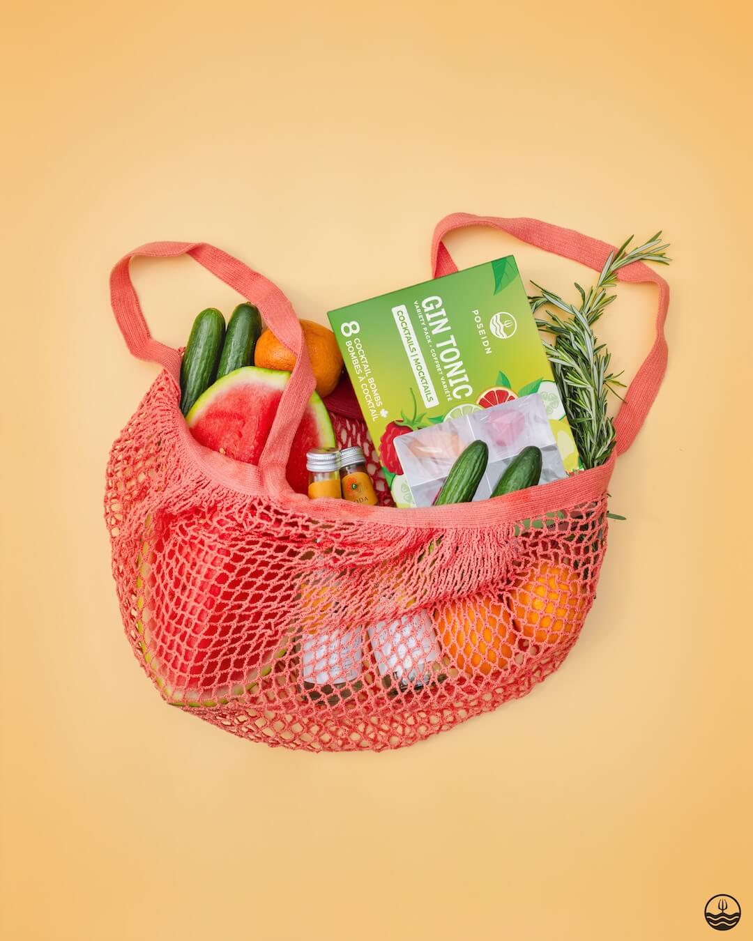 Red mesh bag filled with groceries including vegetables and a box on a yellow background