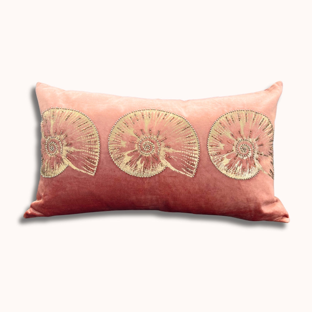 Decorative pillow with gold floral patterns on a pink background