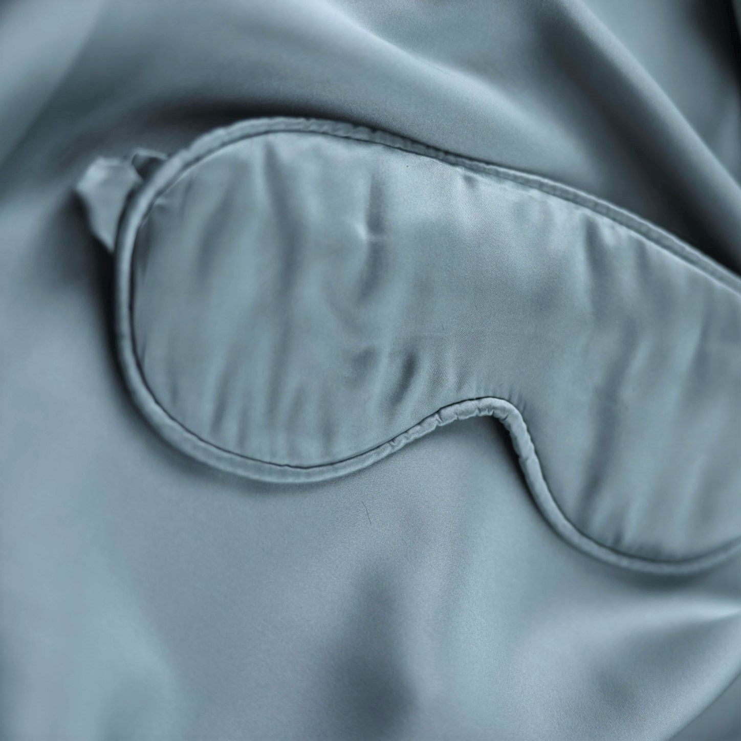Gray sleep mask on a matching fabric background