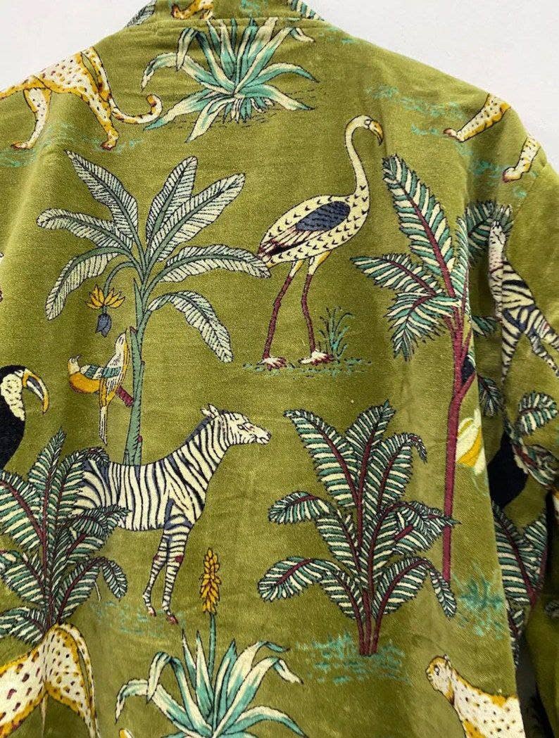 Close-up of lush green jungle print with exotic animals on velvet kimono, showcasing organic cotton handmade craftsmanship.