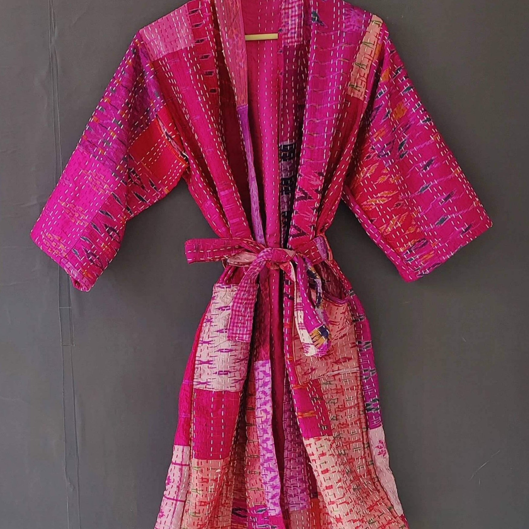 Handmade silk quilted kimono jacket in vibrant pink, perfect as a beach cover-up or robe, featuring a matching belt.