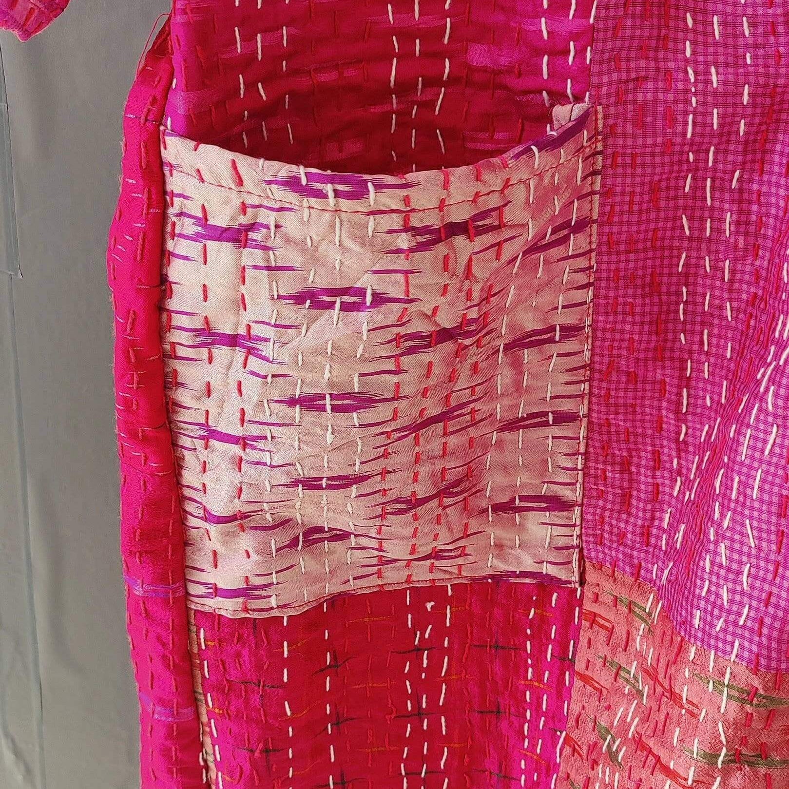 Close-up of a silk quilted kimono with vibrant pink patterns and a pocket, showcasing handmade Kantha craftsmanship.