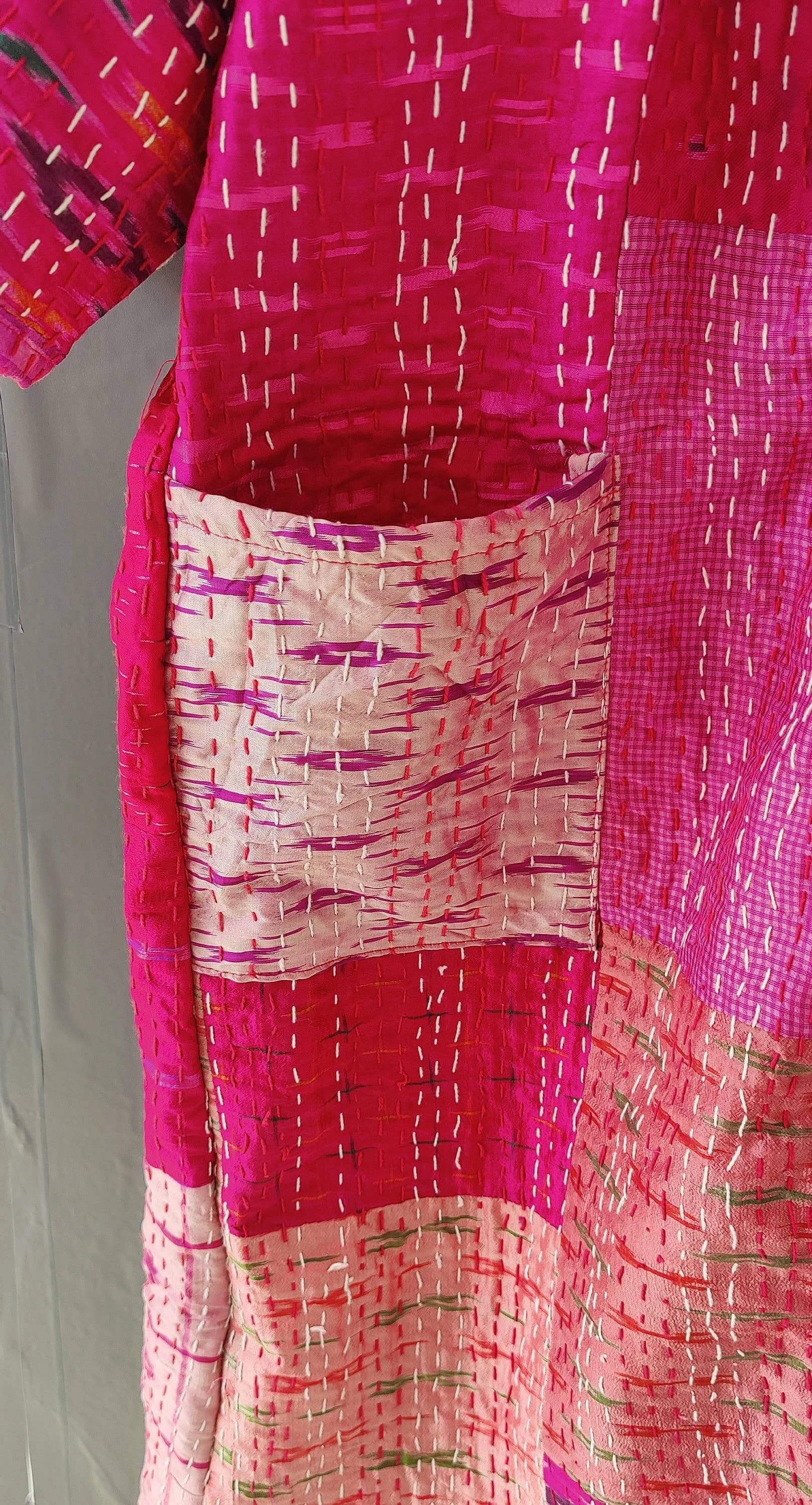 Close-up of a silk quilted kimono with vibrant pink patterns and a pocket, showcasing handmade Kantha craftsmanship.