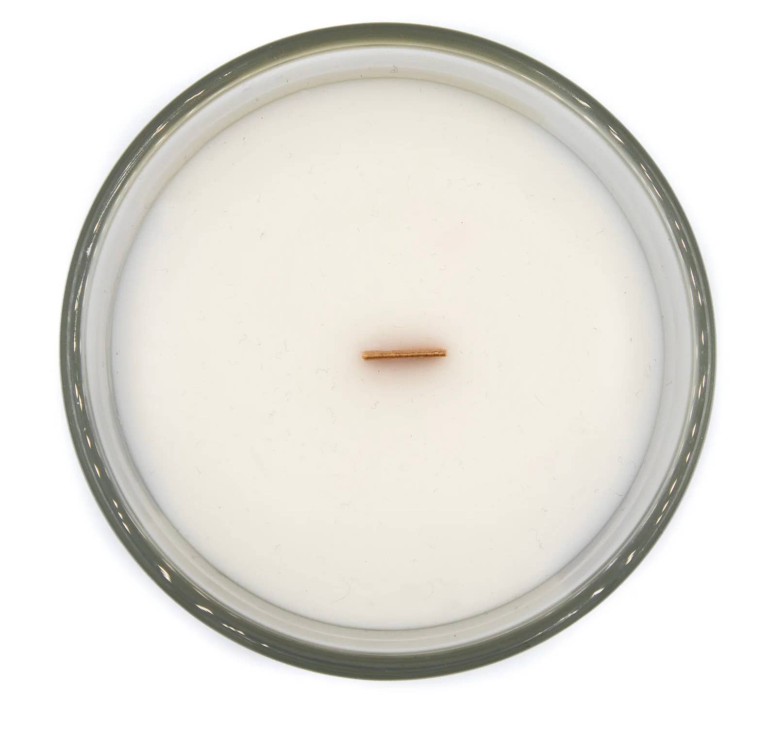 Top view of a coconut apricot wax candle in a clear glass votive with a wooden wick.