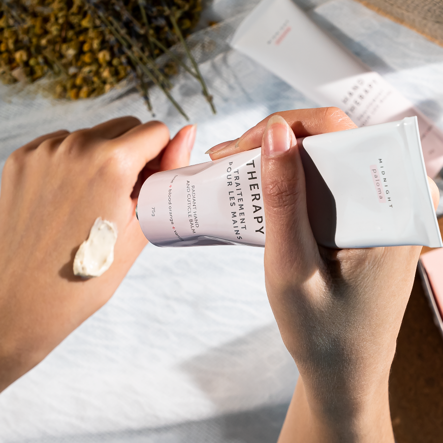 Two hands holding skincare products with a blurred background
