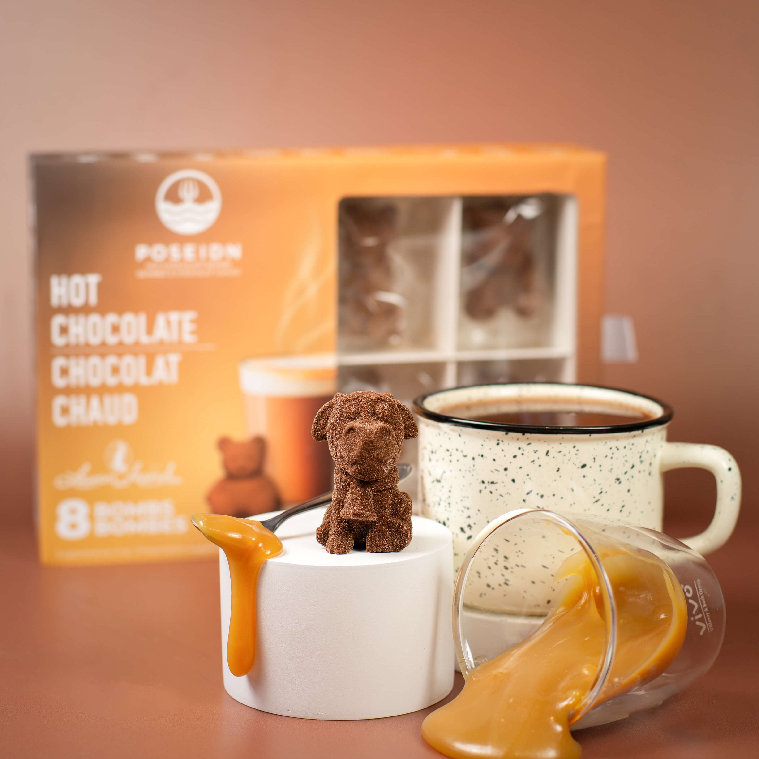 Hot chocolate set with a mug, box, and small dog-shaped container on a brown background