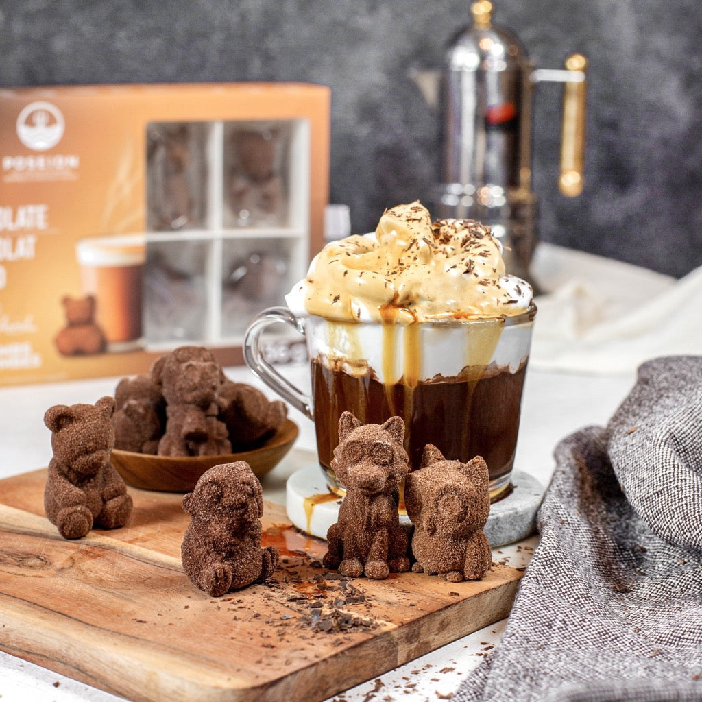 Chocolate bear figurines on a wooden board with a hot chocolate drink in the background.