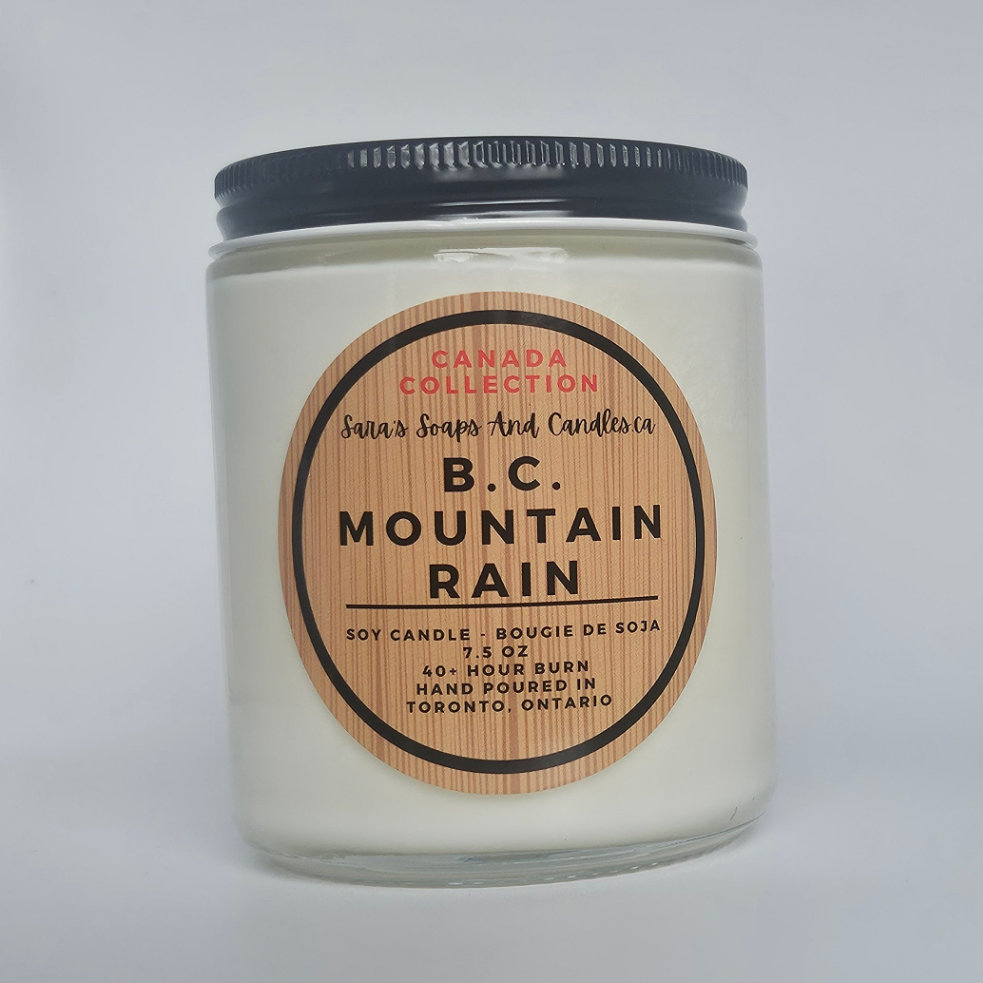 Candle jar labeled 'B.C. Mountain Rain' with a wooden label on a white background