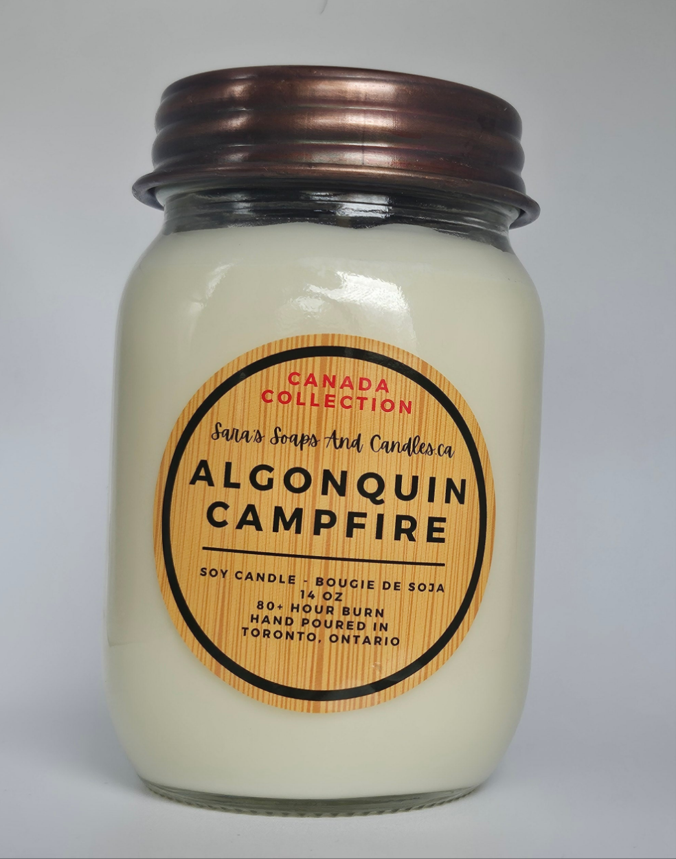 Jar candle labeled 'Algonquin Campfire' from Santa's Soaps and Candles on a white background 