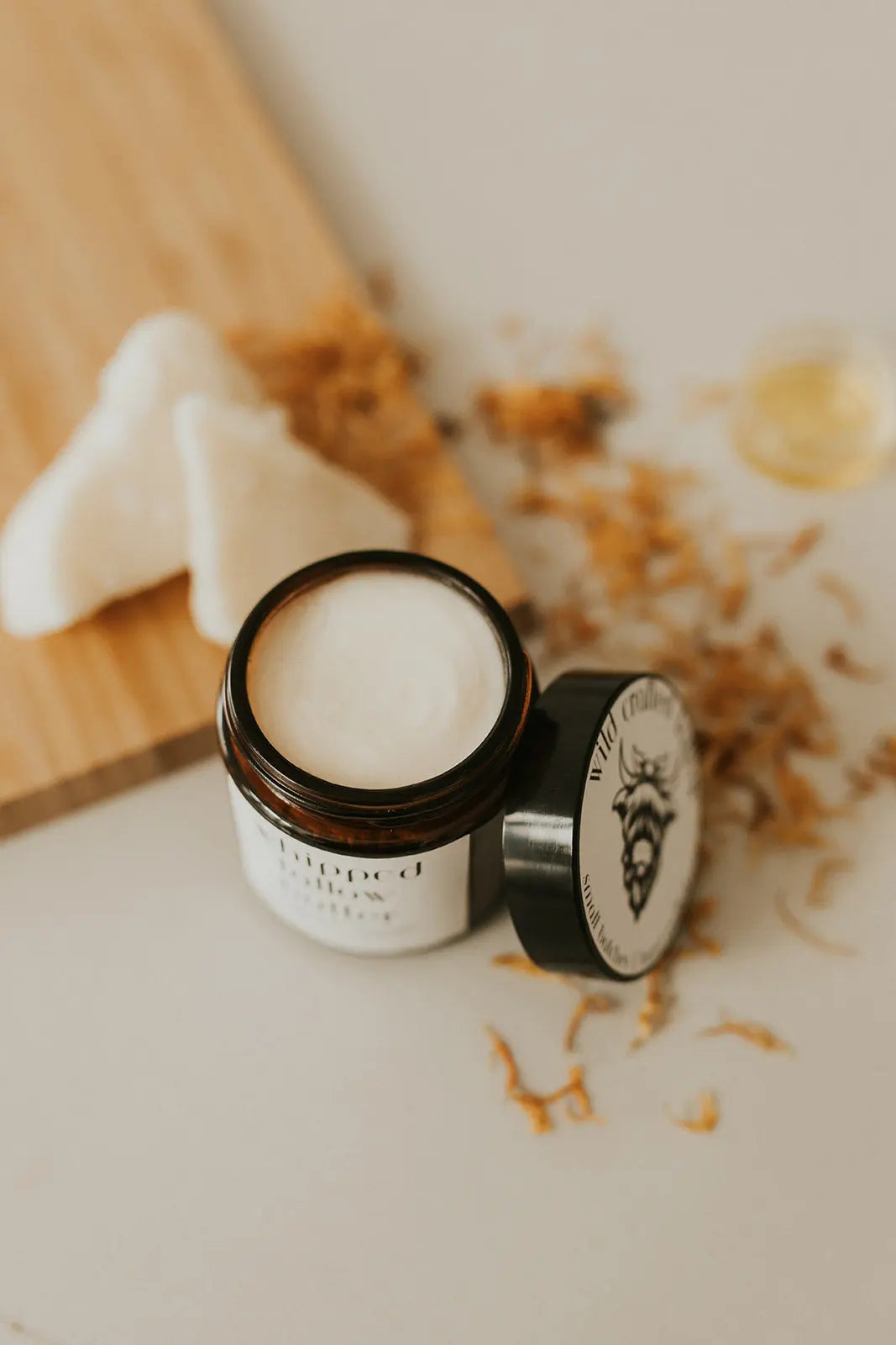 Jar of cream with a lid on a light surface, with a blurred background