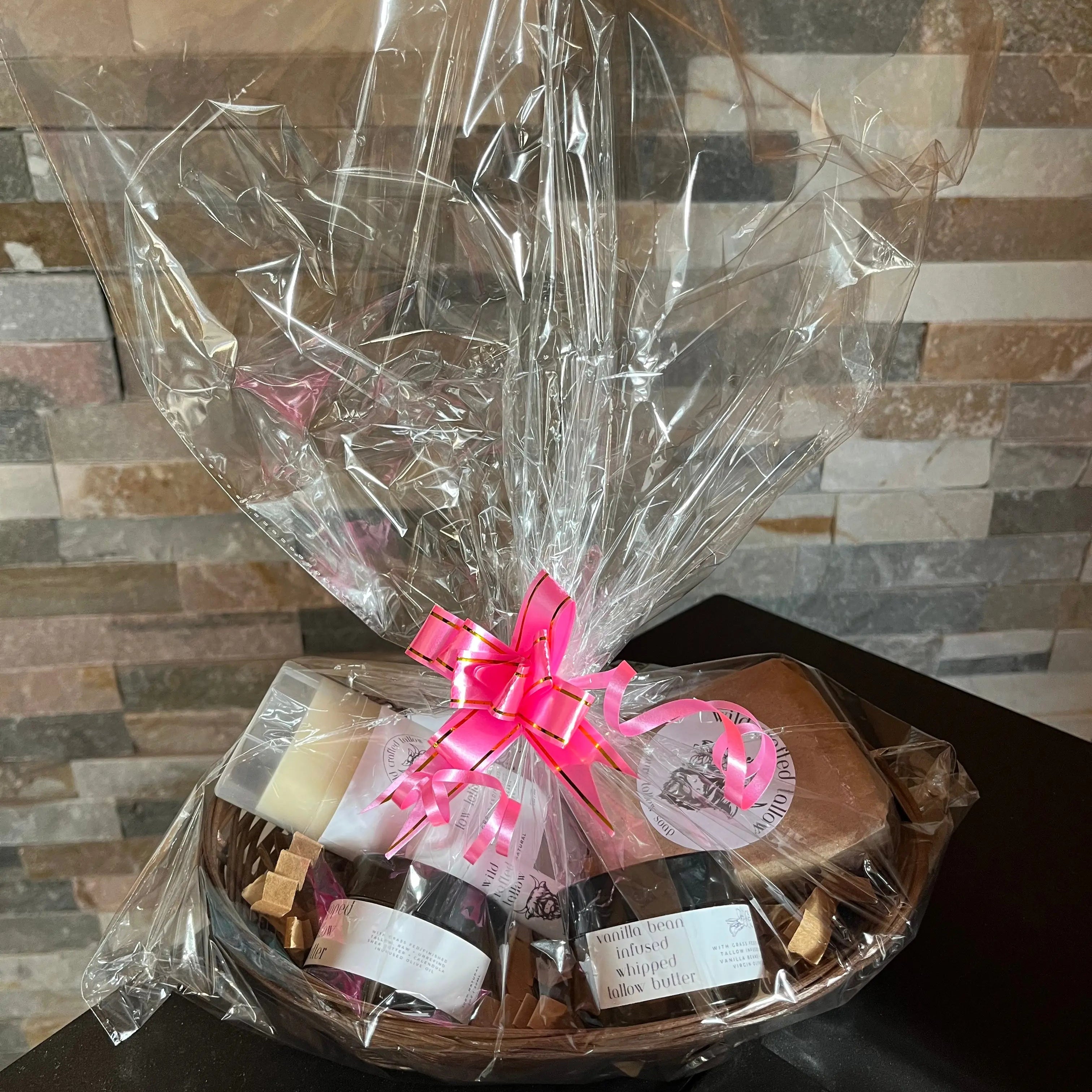 Gift basket with a pink bow on a wooden surface