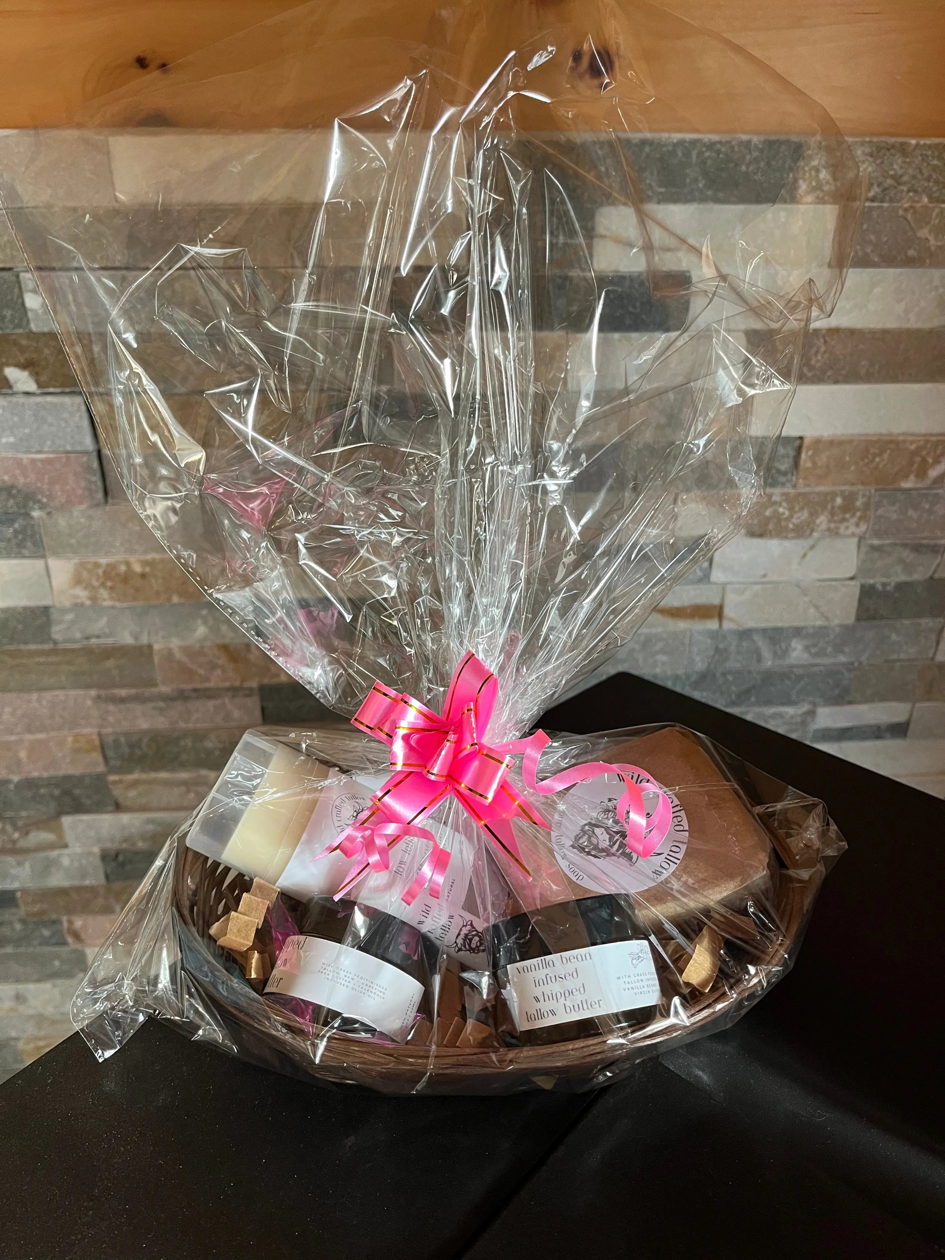 Gift basket with a pink bow on a wooden surface