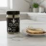 Jar of Miel Brut on a kitchen counter with toast and butter