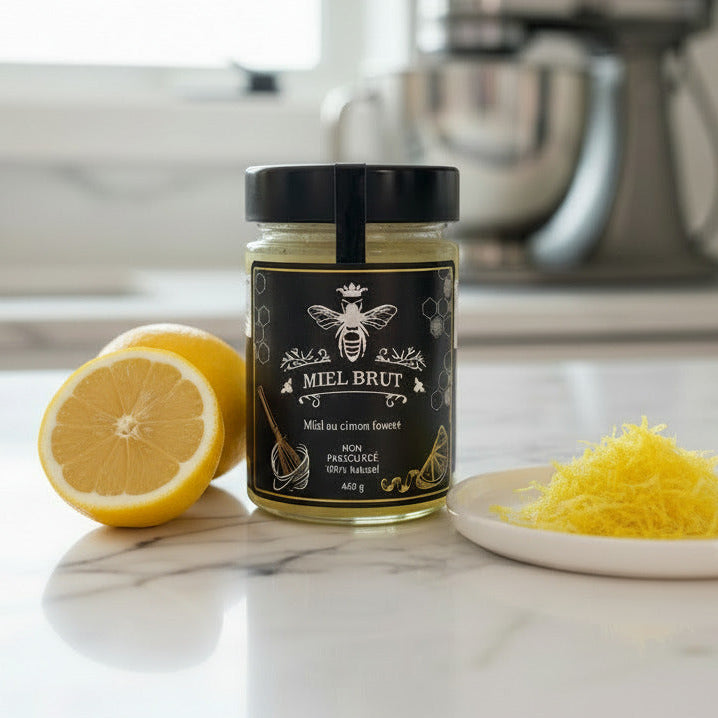 Jar of 'Mel Brut' on a kitchen counter with lemons and honeycomb.