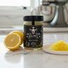 Jar of 'Mel Brut' on a kitchen counter with lemons and honeycomb.