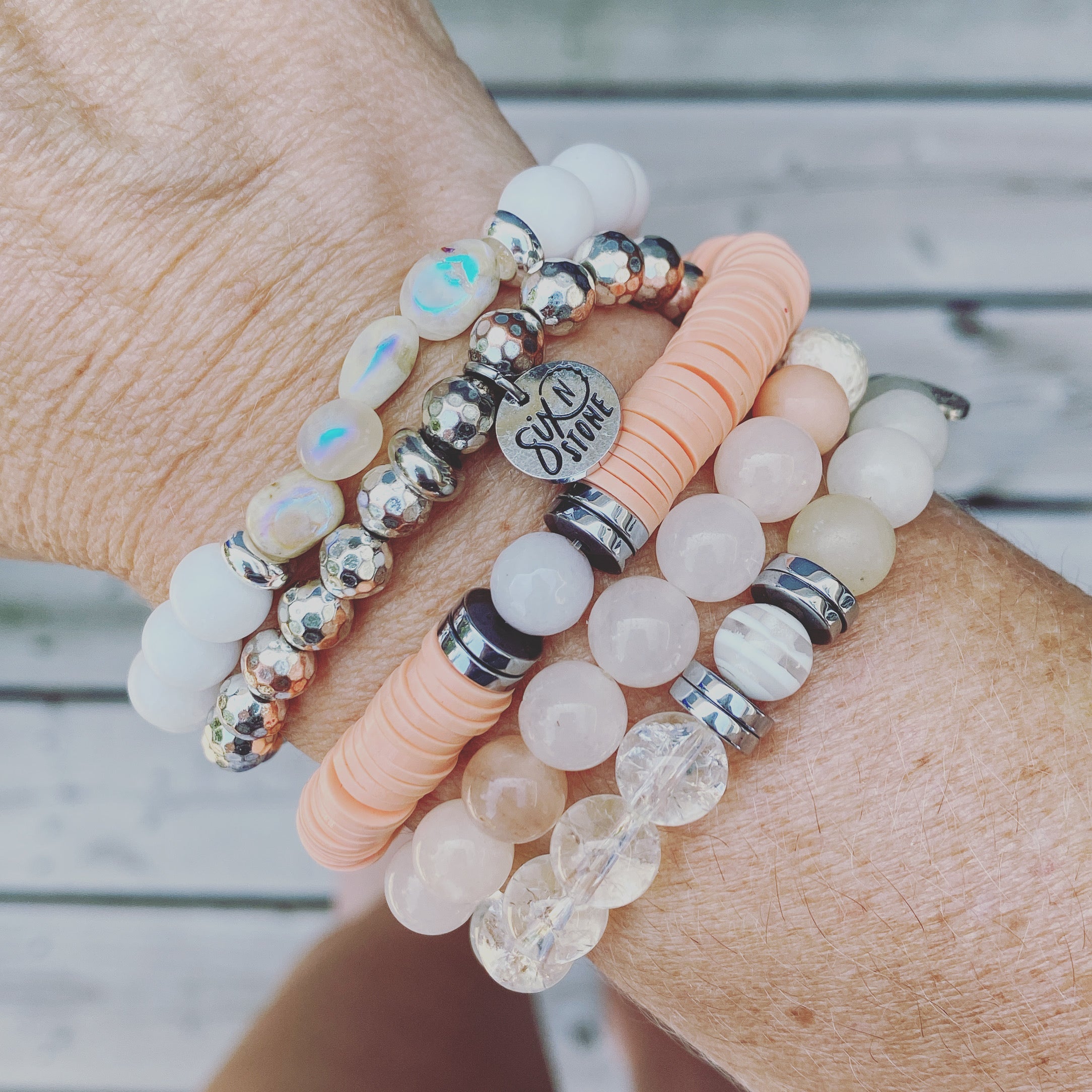 Close-up of a wrist wearing multiple beaded bracelets from Six N Stone