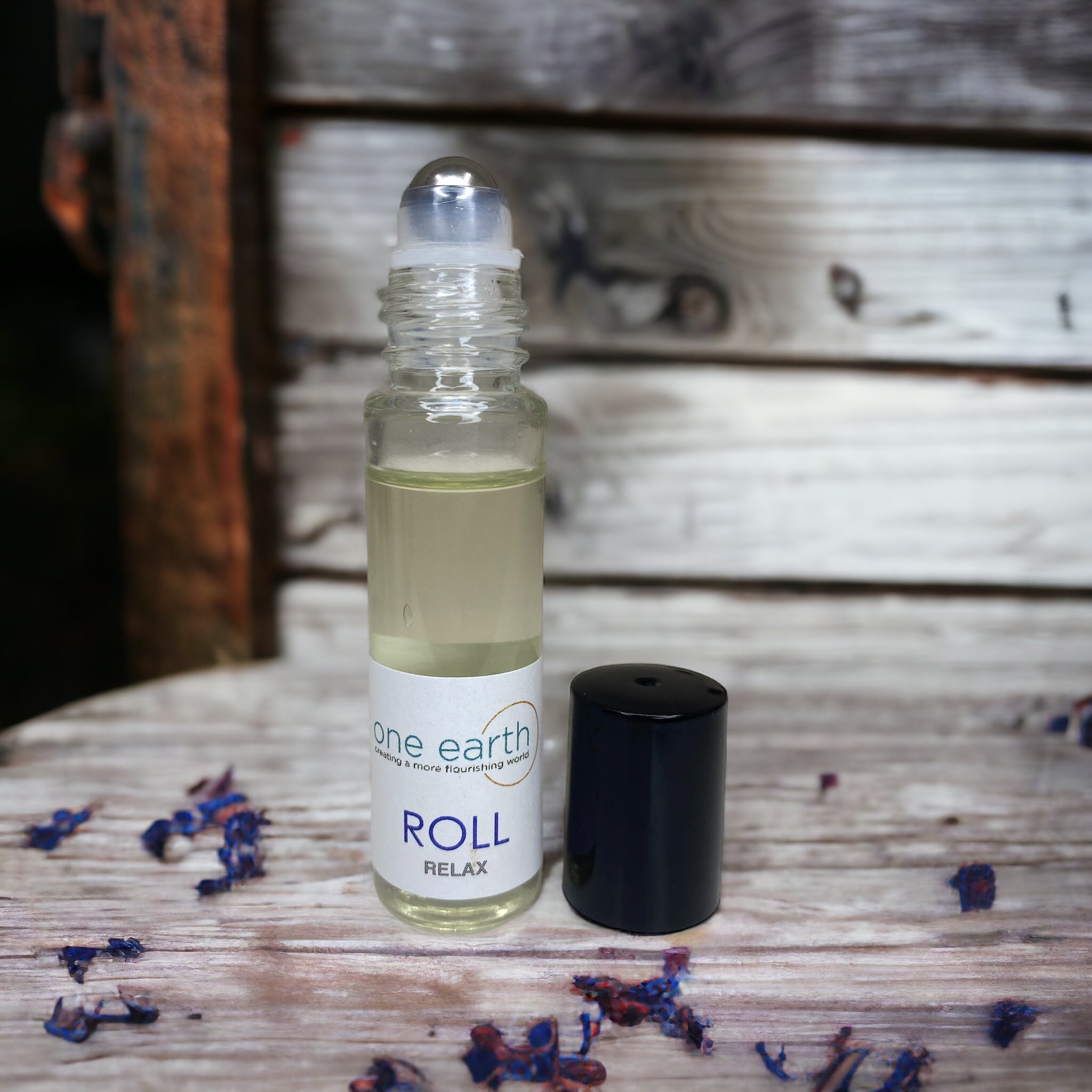 Roll-on bottle labeled 'one earth' with a wooden background