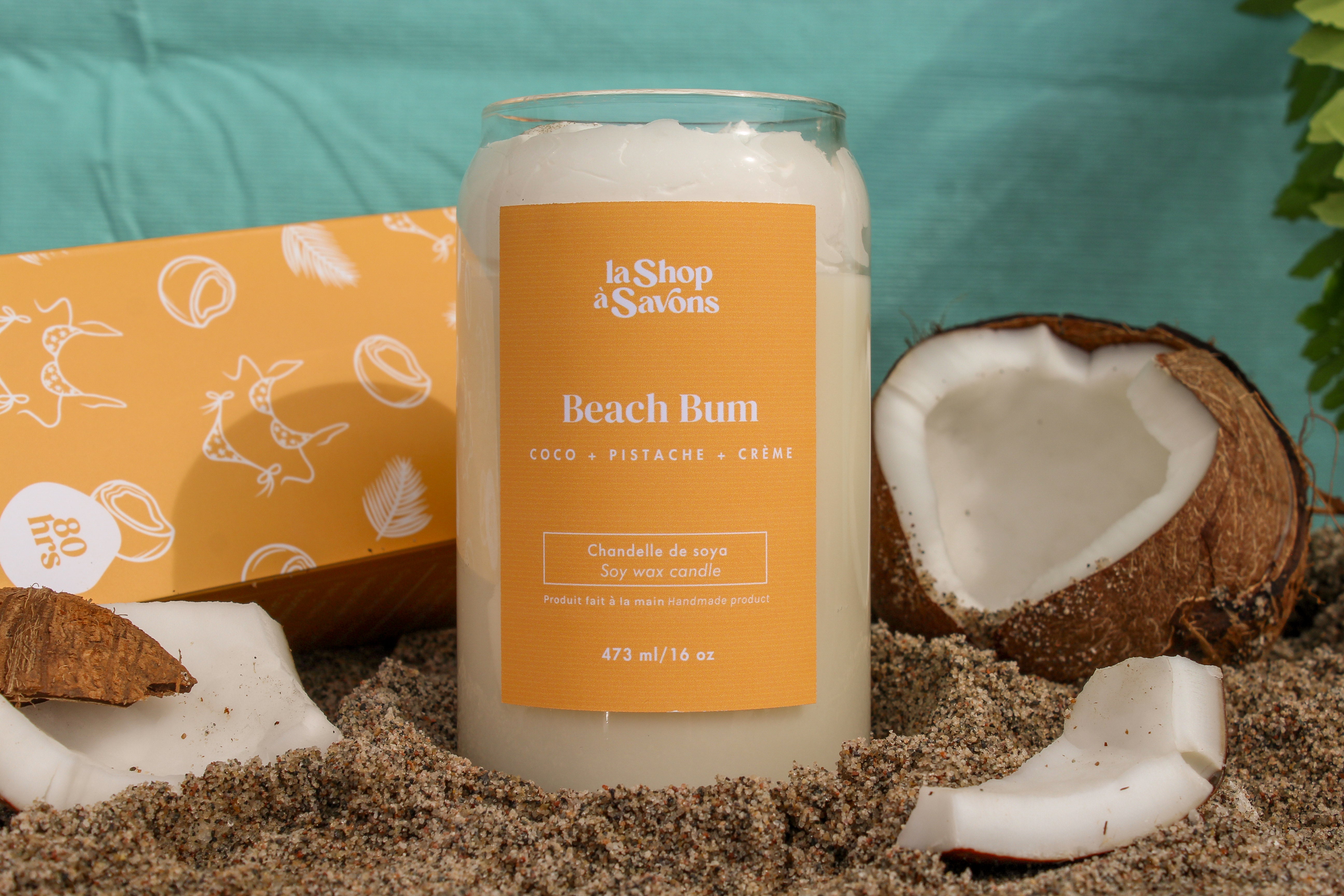 Candle labeled 'Beach Bum' with coconut elements on a sandy background