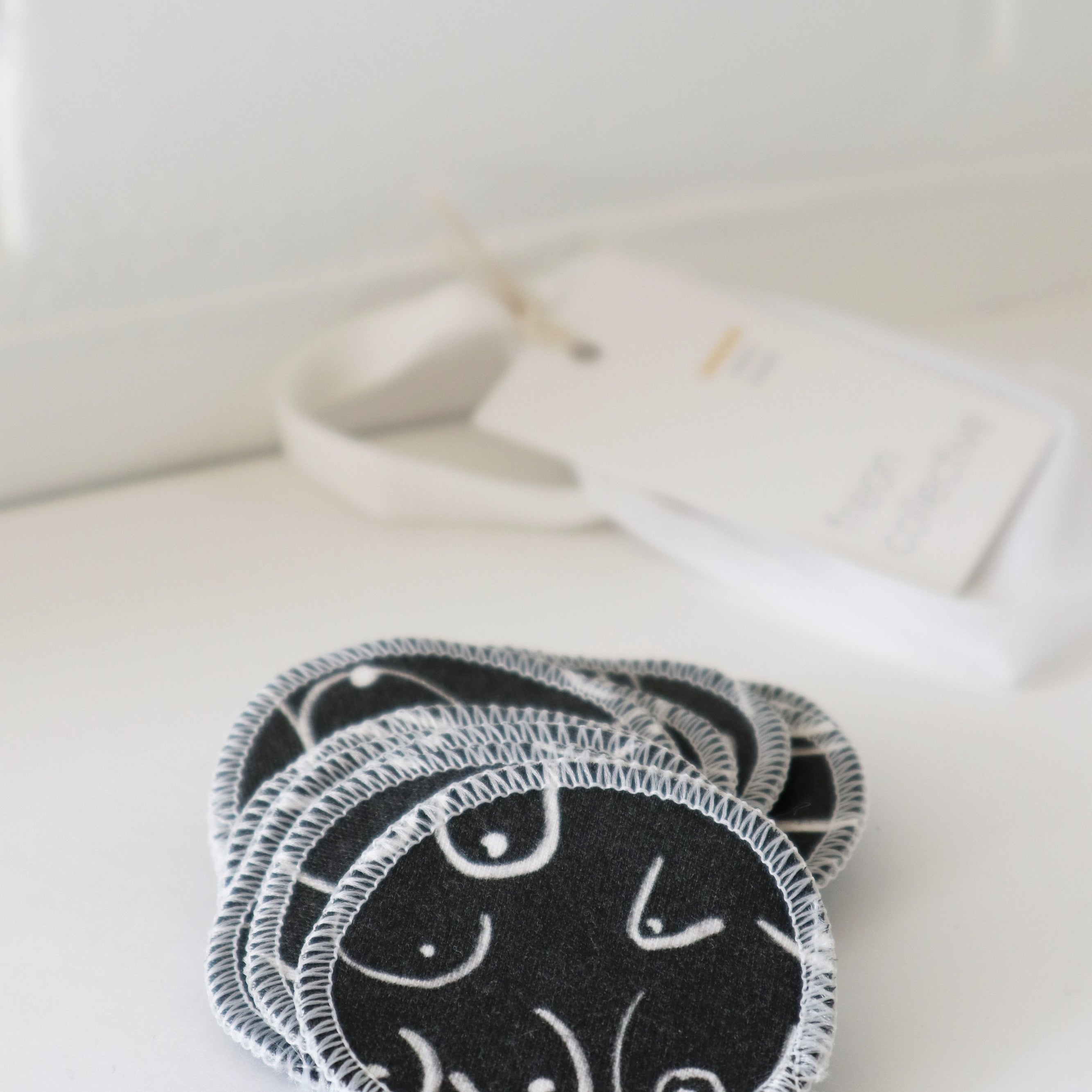 Black and white resuable cotton makeup pads on a white cloth by Freon Collective 2