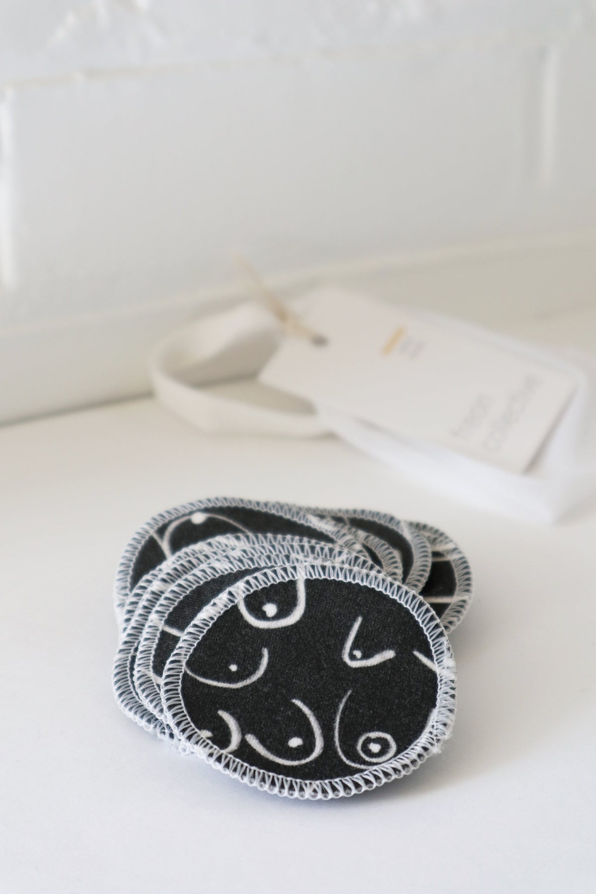 Black and white resuable cotton makeup pads on a white cloth by Freon Collective 2