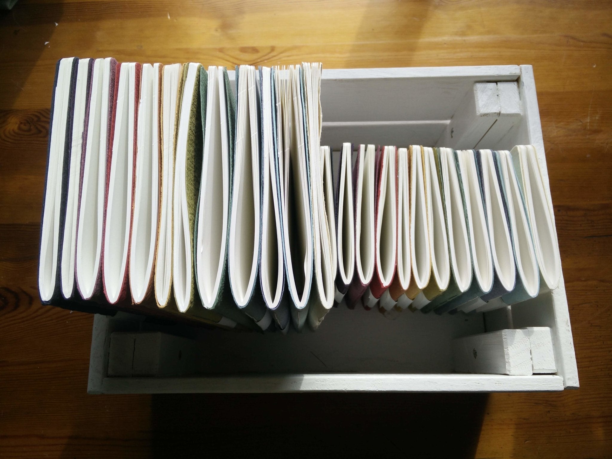 Stack of books with a white box on a wooden surface Creative Artifacts HQ plantable 