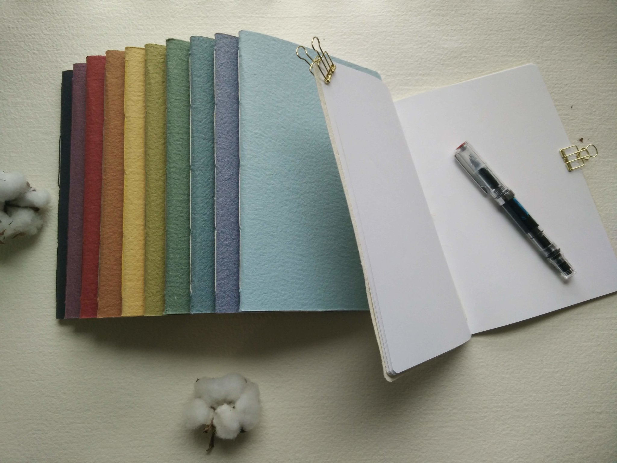Set of colorful notebooks with a pen on a light surface Creative Artifacts HQ plantable handmade