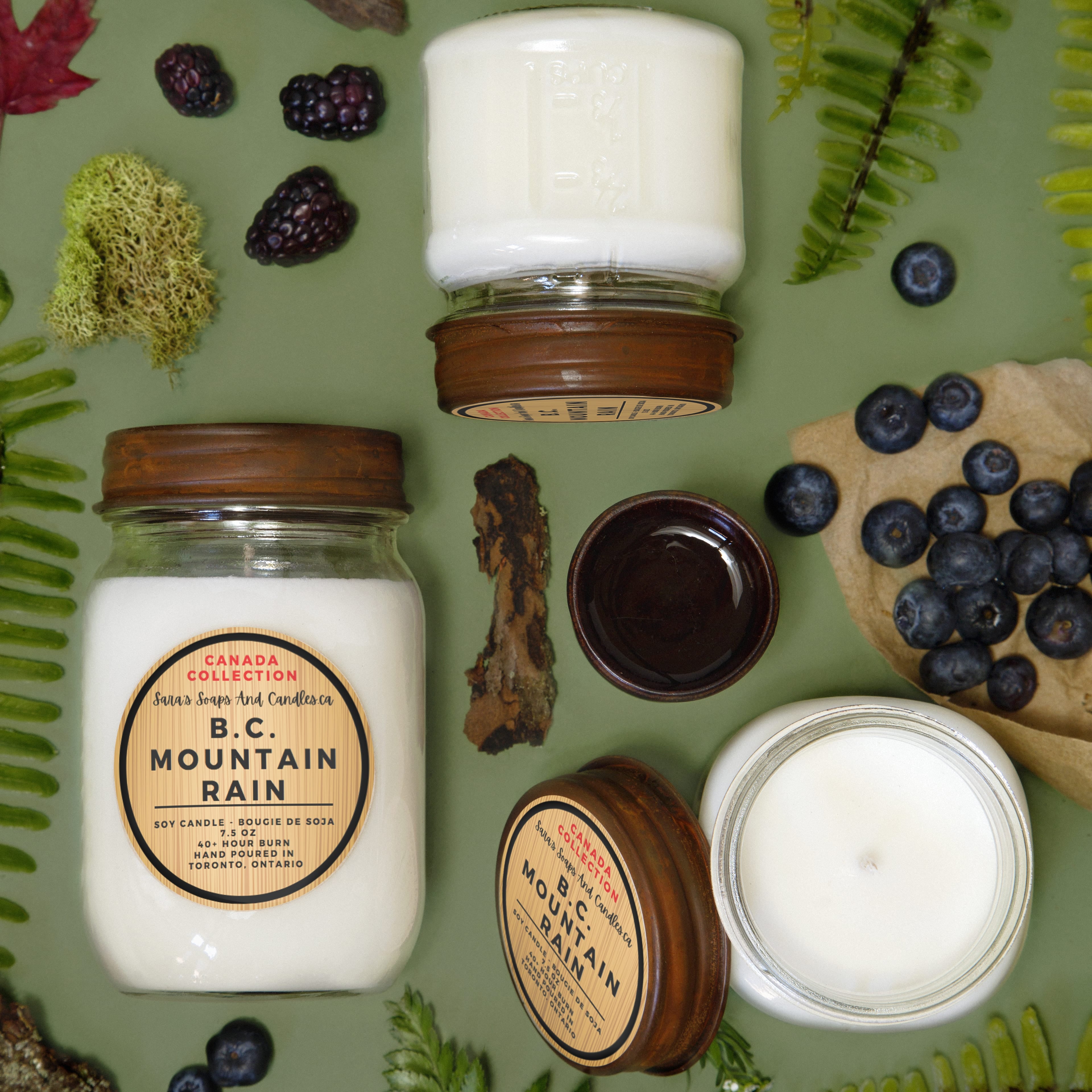 Candles with 'Mountain Rain' label surrounded by nature-themed elements on a green background