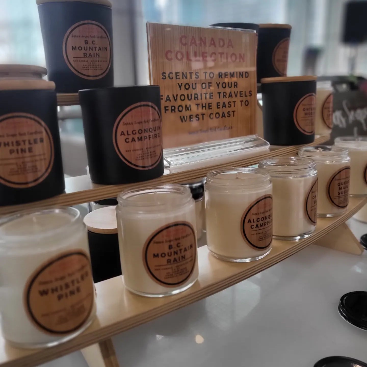 Shelf displaying candles with branding and product names.