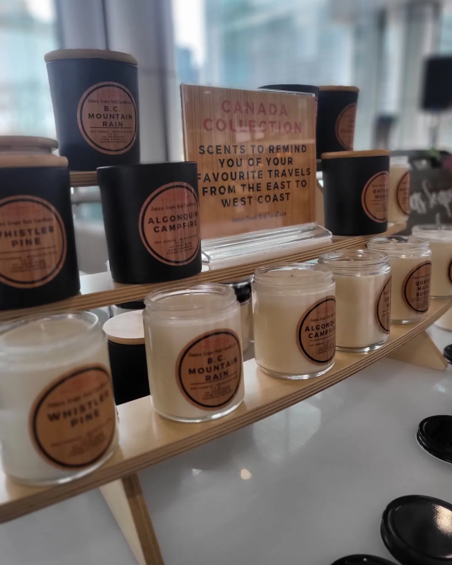 Shelf displaying candles with branding and product names.