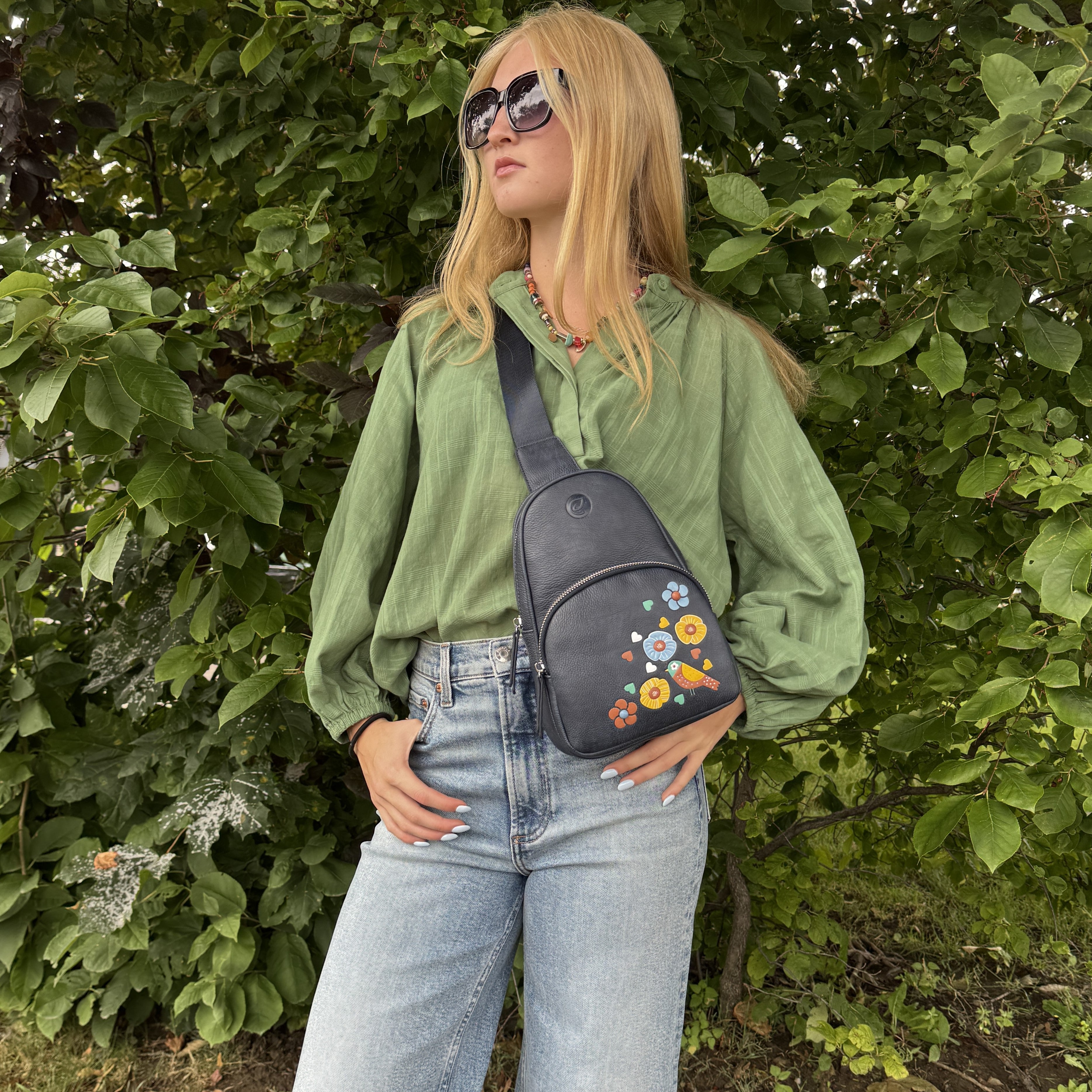 Navy Jay Sling bag floral bird detail lifestyle standing front