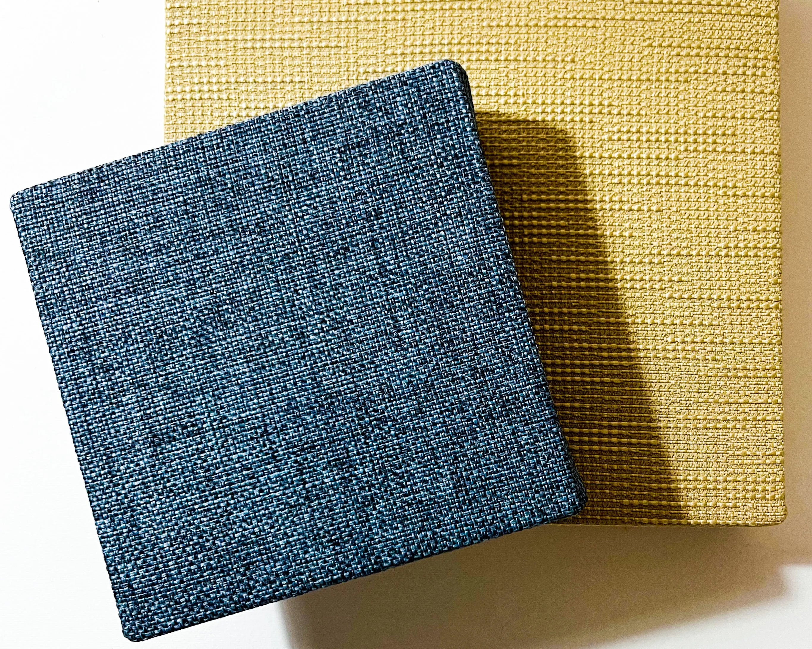 Two square textured tiles, one blue and one yellow, on a white background.
