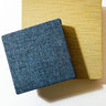 Two square textured tiles, one blue and one yellow, on a white background.