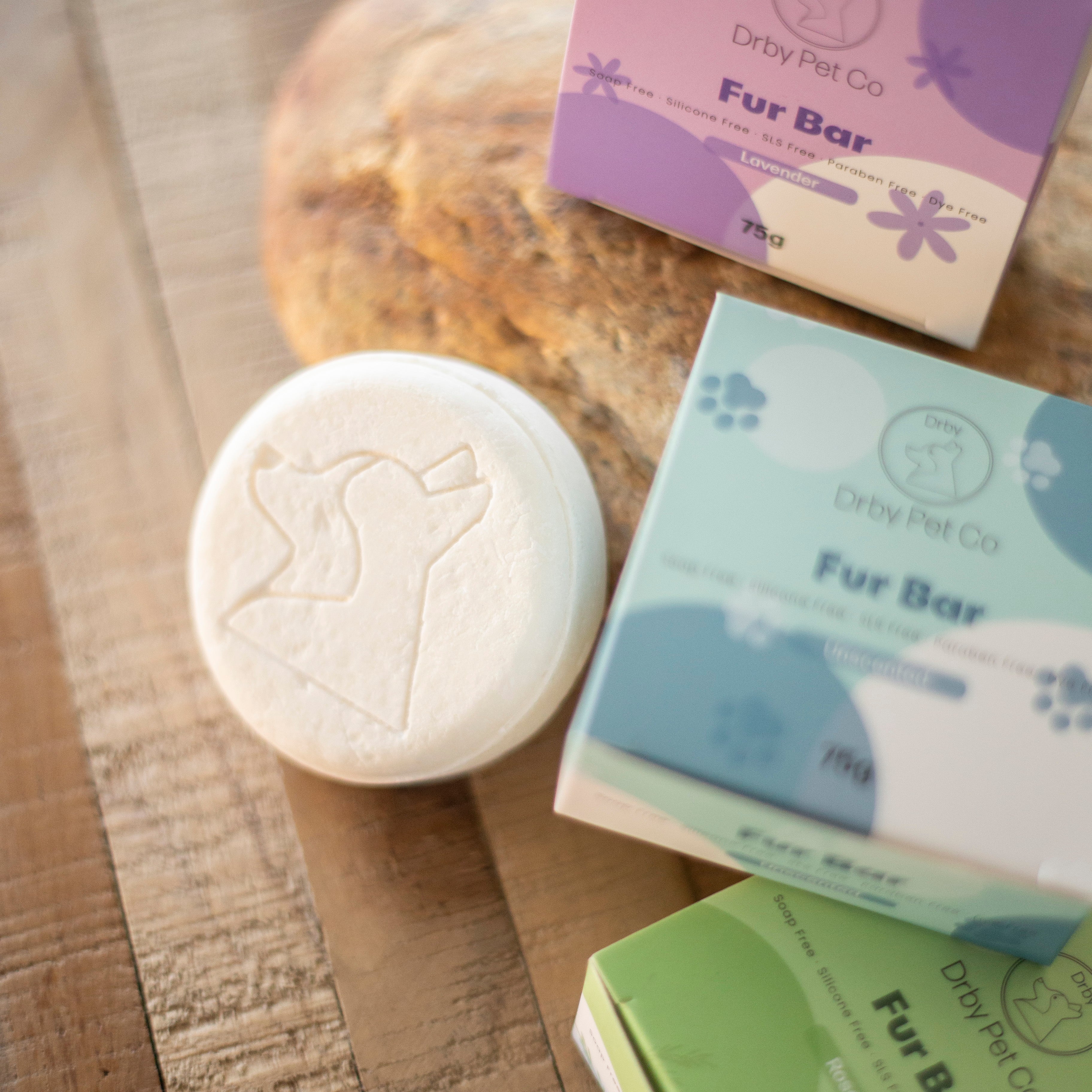 Pet grooming products including a Fur Bar and packaging on a wooden surface