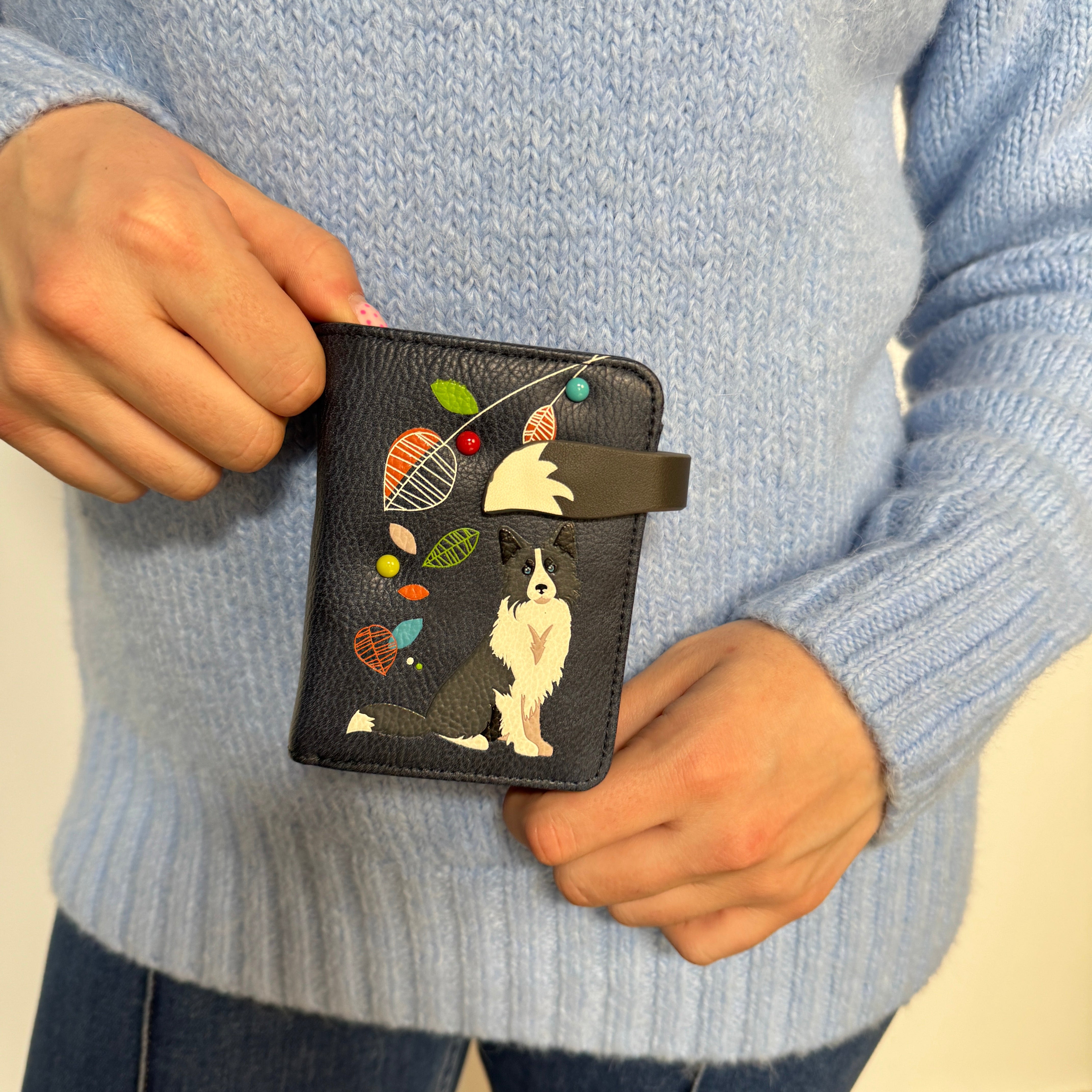 A Espe Vegan Corp wallet a painted Border Collie and colorful birdseed details.
