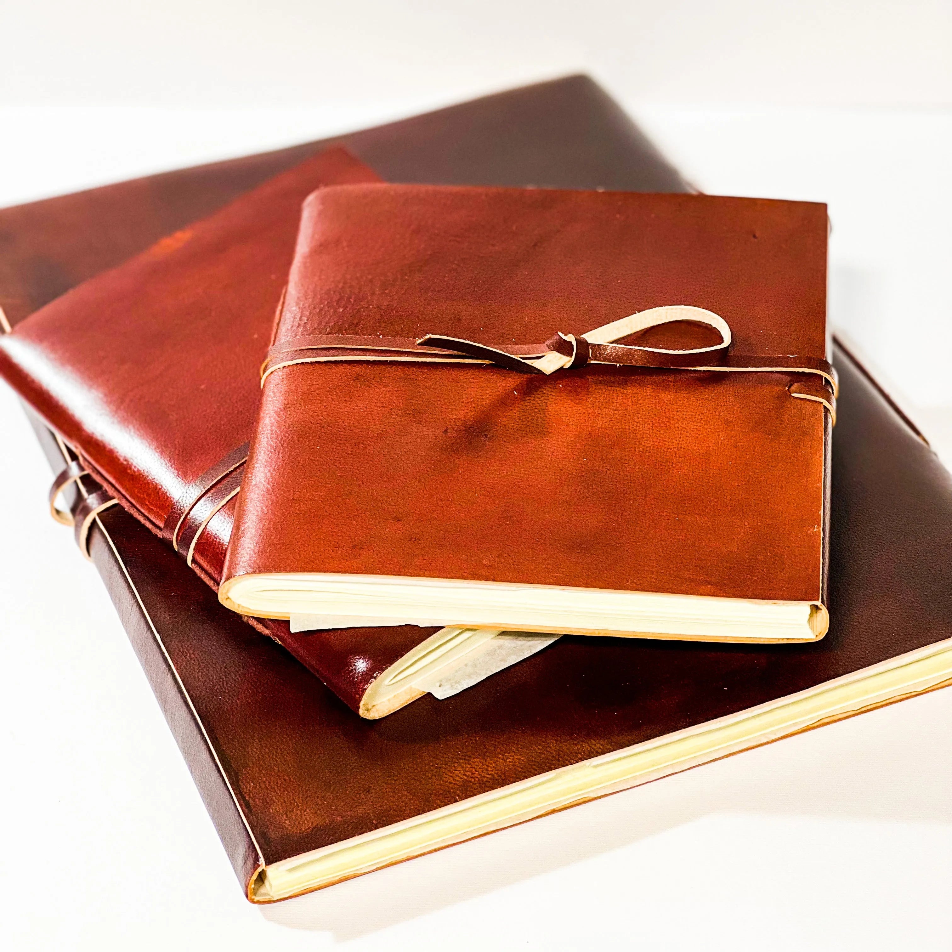 Stack of leather-bound books with a gold ribbon on a white background