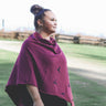 Woman wearing a purple poncho with a nature background