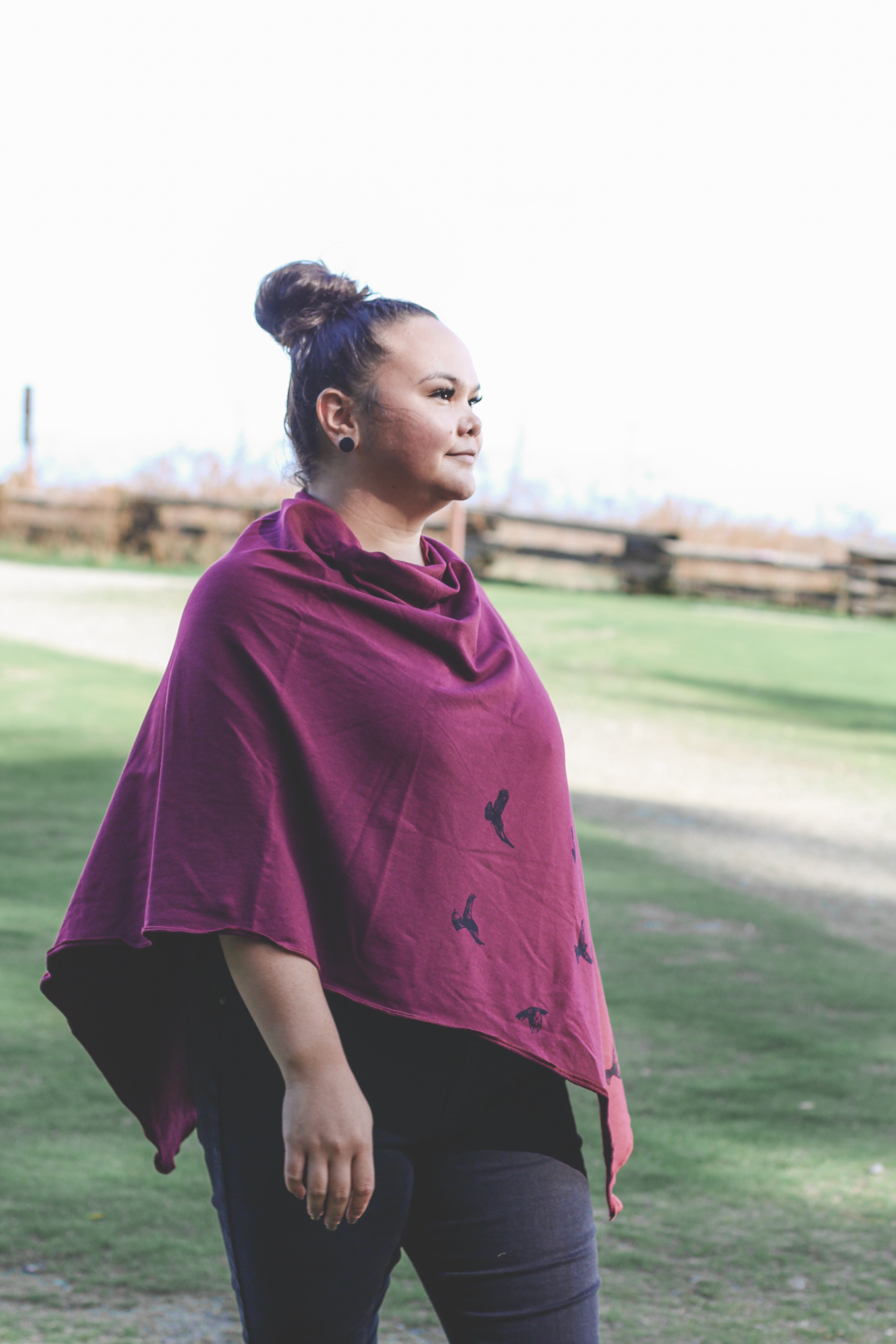 Woman wearing a purple poncho with a nature background