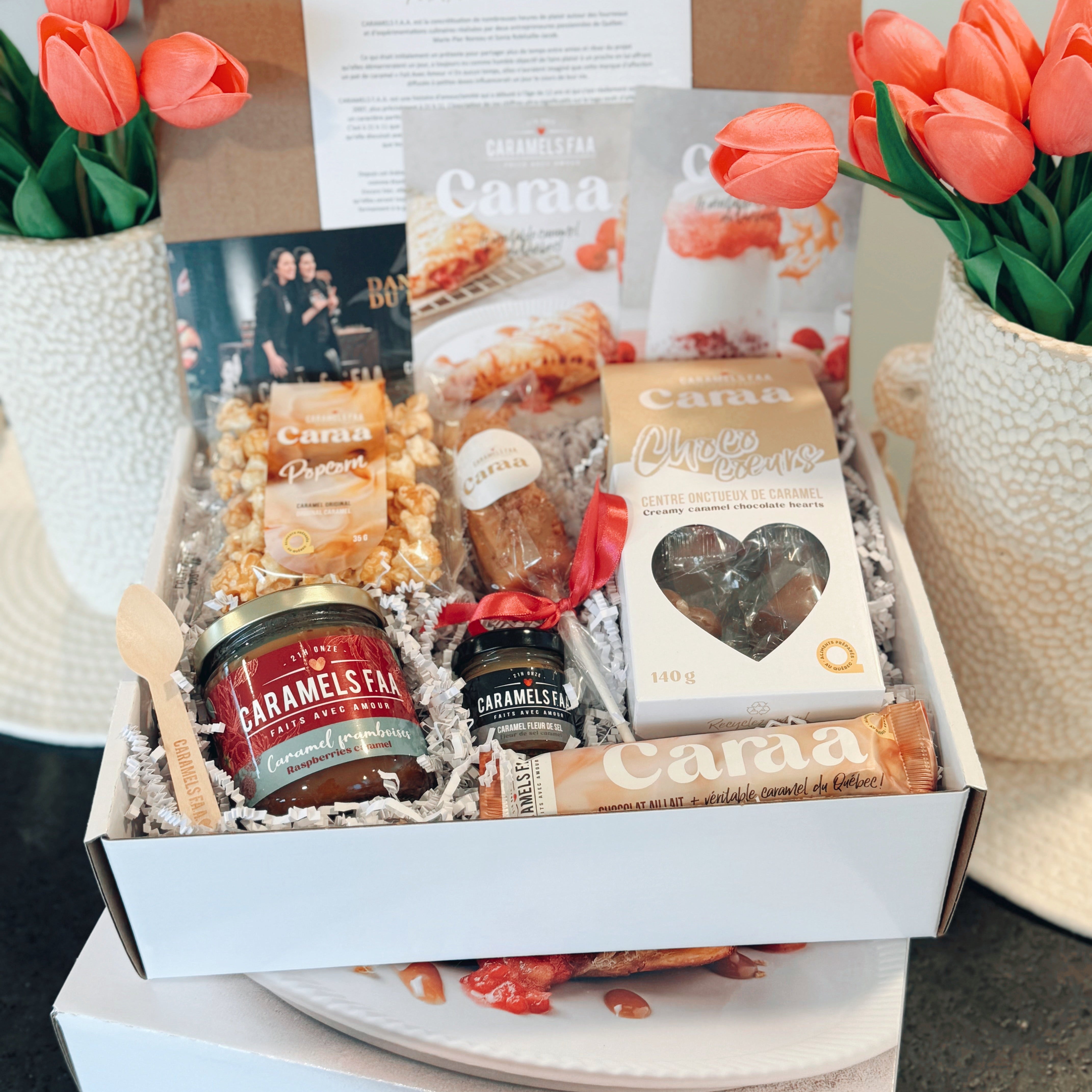 Gourmet gift box with snacks and a card, branded 'Caraa', on a neutral background.