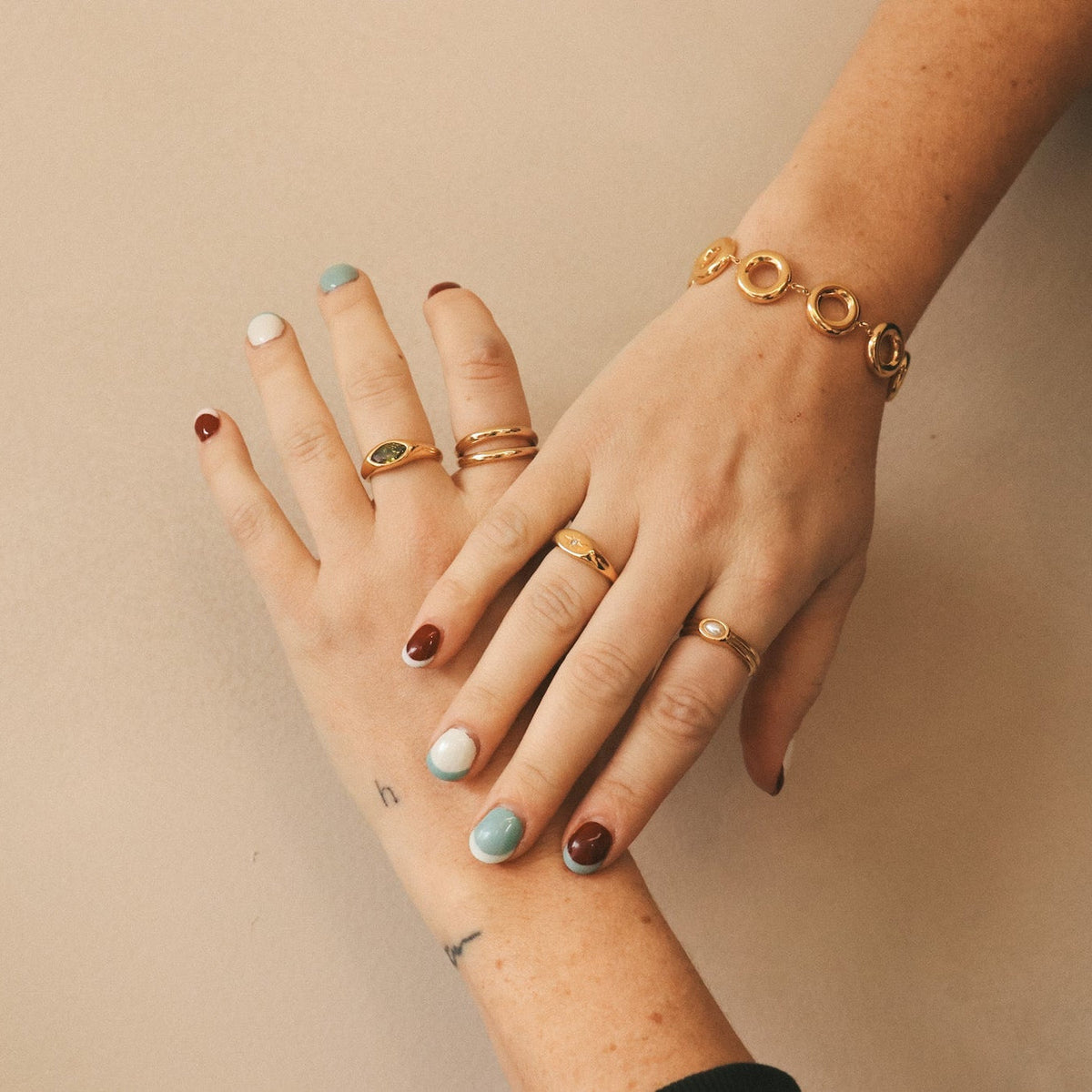 Pair of hands with multiple gold rings and a bracelet | HoraceJewelry