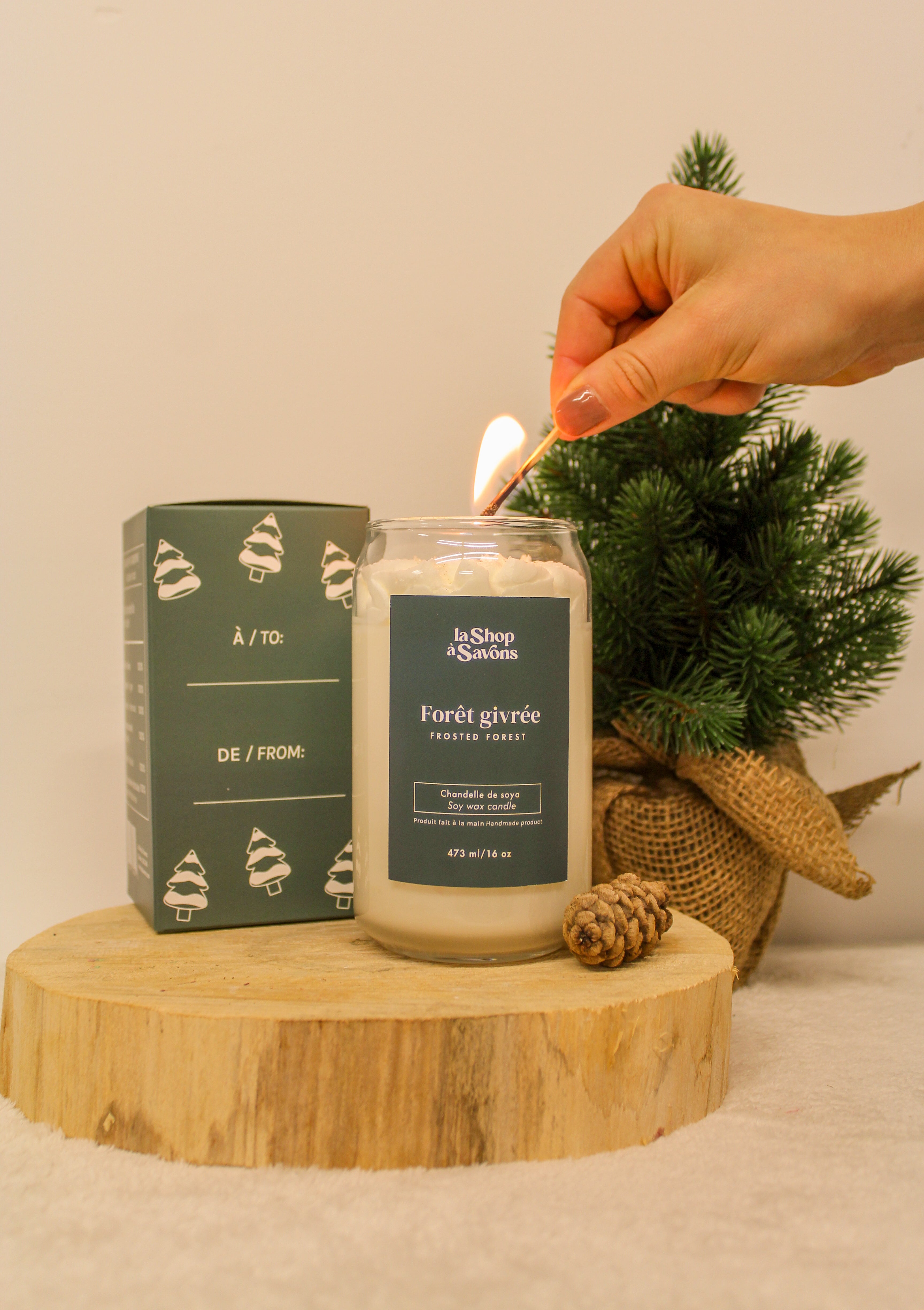 Candle being lit with a decorative box and small tree in the background