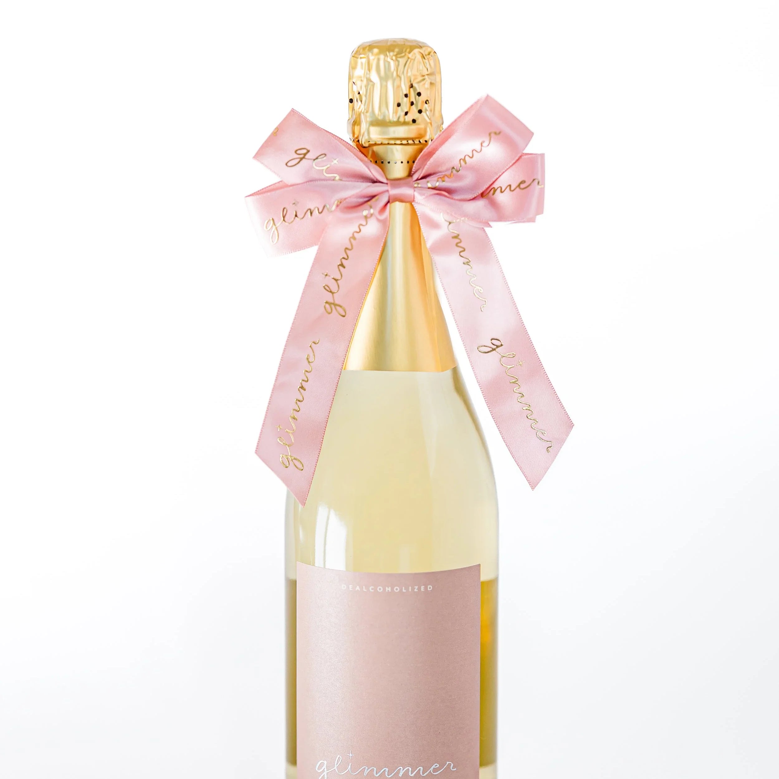 Bottle of sparkling wine with a pink ribbon on a white background