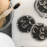 Black and white resuable cotton makeup pads on a white cloth by Freon Collective