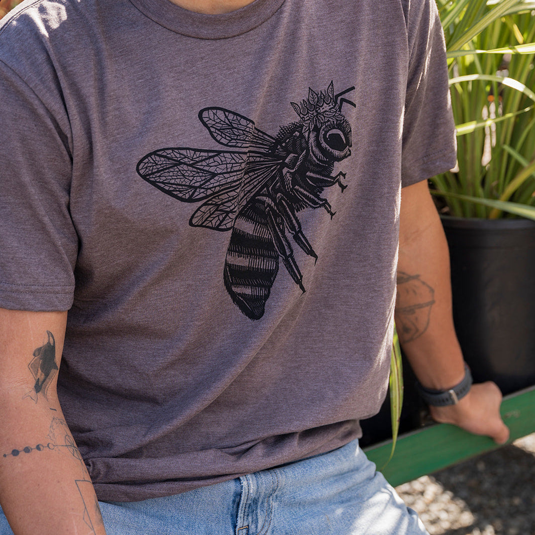 Man wearing a gray t-shirt with a bee design outdoors