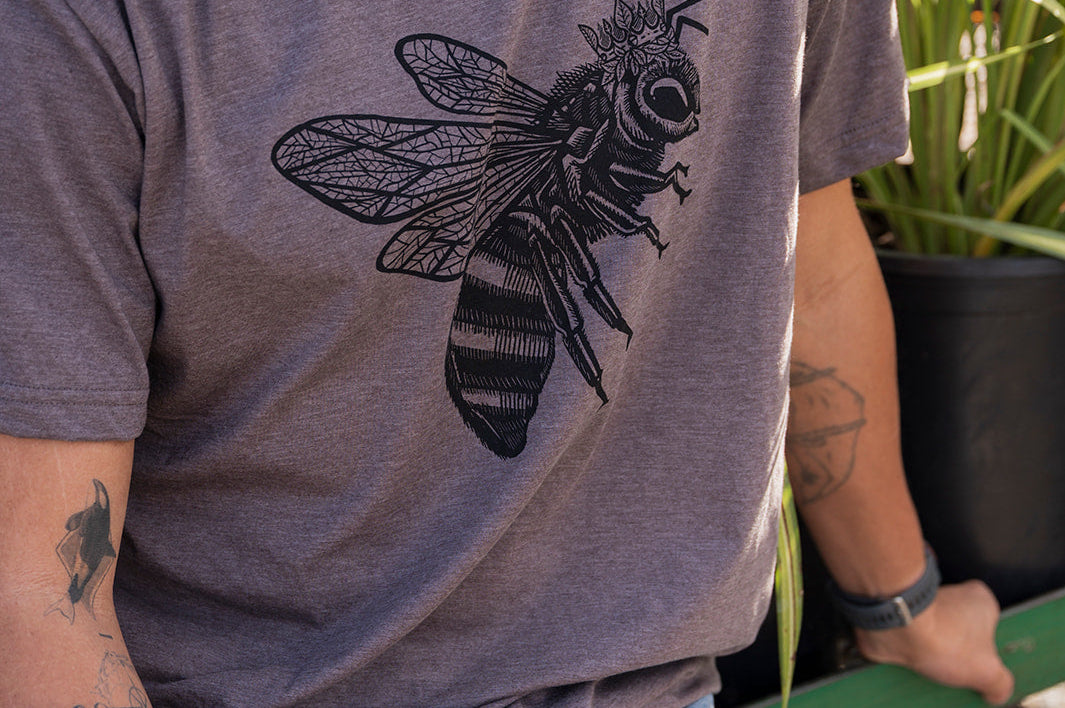 Man wearing a gray t-shirt with a bee design outdoors