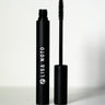 LISA NOTO Volumizing Natural Mascarain a matte black tube, shown with the wand removed and standing beside the cap on a clean white background.