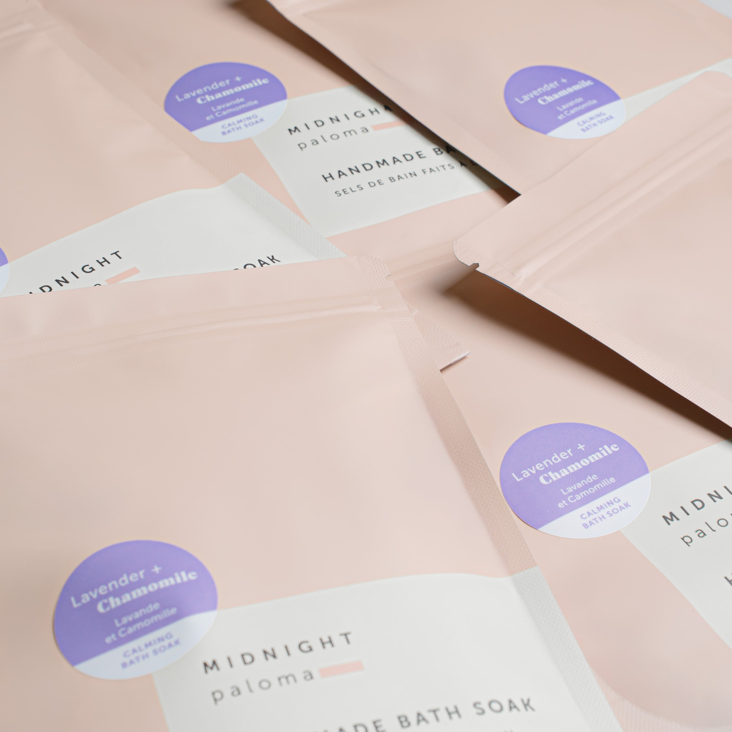Bath soaks with 'Midnight Paloma' branding on a light pink background